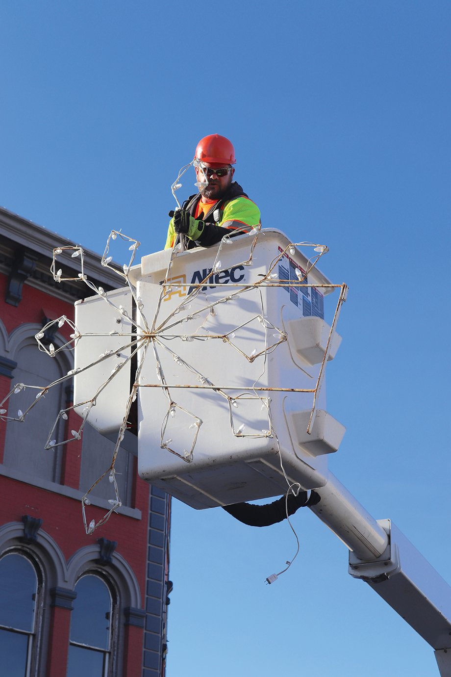 Tom Edwards makes his way to the top of another Main Street light pole Tuesday to transform downtown Crawfordsville into a virtual winter wonderland.